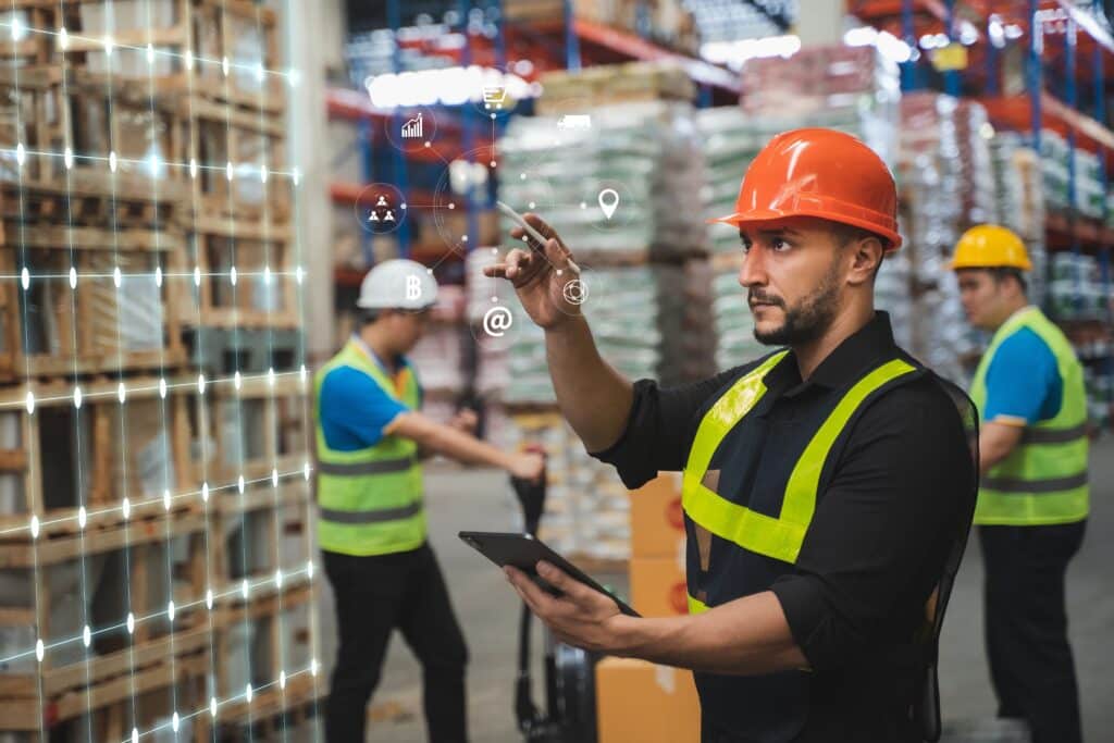 Warehouse worker using a digital interface and tablet to manage inventory in a modern automated warehouse