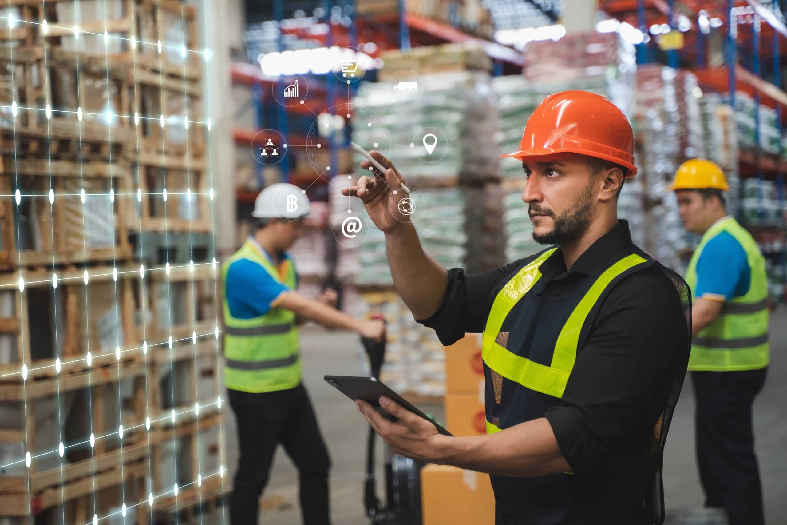 Warehouse worker using a digital interface and tablet to manage inventory in a modern automated warehouse