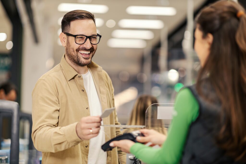 A,Smiling,Man,Is,Purchasing,With,Credit,Card,On,Pos